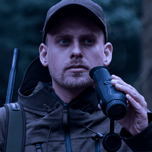 A hunger with a rifle on his shoulder about to look through a Zeiss DTI 3/35 thermal imaging camera.