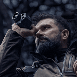 Man shown looking through a Pulsar Axion 2 LRF thermal monocular.