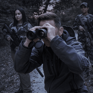 Man shown looking through a pair of Pulsar Merger LRF binoculars.