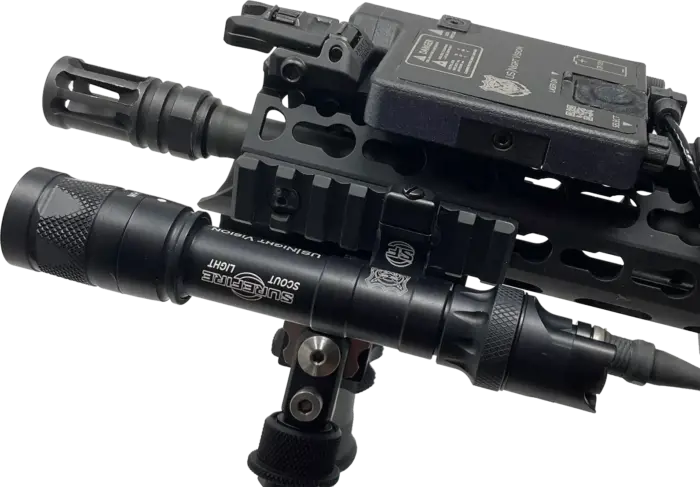 Photo of a black US Night Vision DesignateIR shown mounted to the front of an AR-15 rifle.