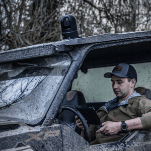 Man shown driving a side-by-side with a InfiRay Outdoor M6 mounted to the roof.